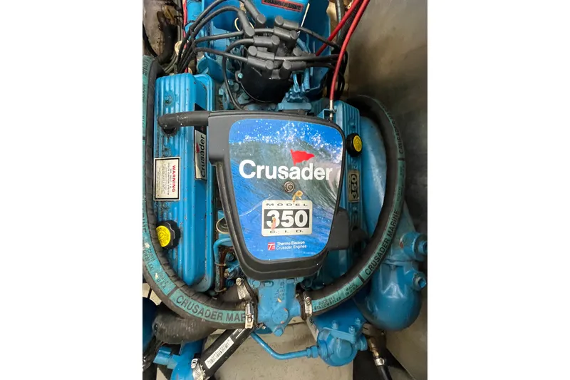 Slide: The Image of Crusader 350 engine in a 1990 Gibson 44 boat, featuring blue components and wiring. - 38