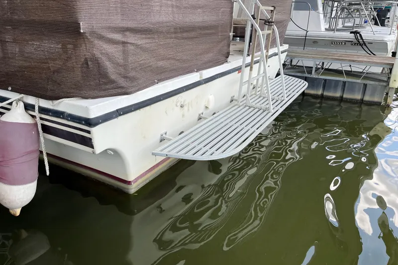 Slide: The Image of 1990 Gibson 44 boat with metal swim platform docked in marina. - 4