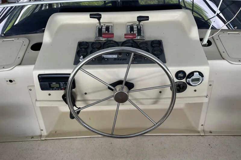 Slide: The Image of 1990 Gibson 44 boat helm with steering wheel and control panel. - 42