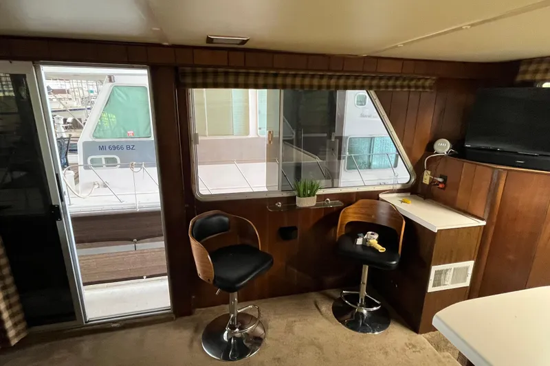 Slide: The Image of Interior of a 1990 Gibson 44 boat with seating and a window view. - 5