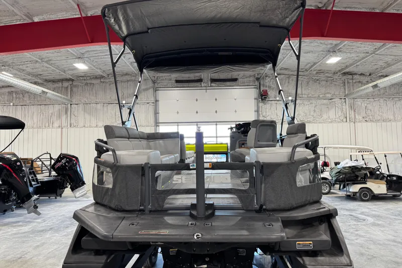 Slide: The Image of 2023 Sea-Doo Switch Cruise 21 pontoon boat in a spacious indoor showroom. - 10