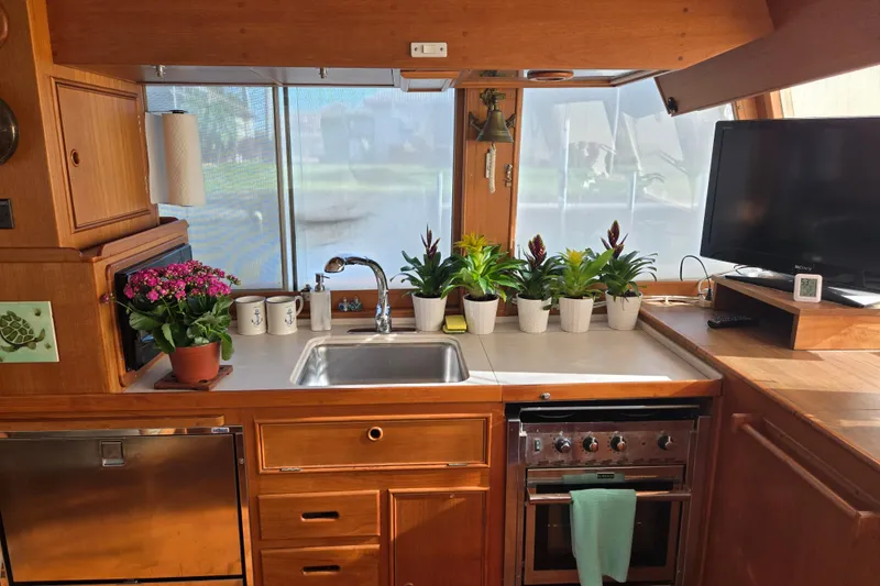 Slide: The Image of Interior of 1992 Grand Banks 46 Classic yacht kitchen with plants and appliances. - 2