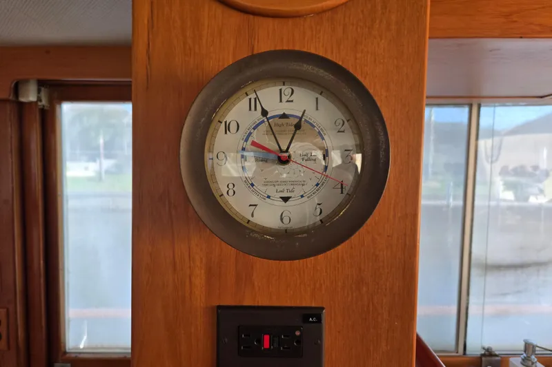 Slide: The Image of Wall-mounted nautical clock inside 1992 Grand Banks 46 Classic yacht, displaying tide information. - 20