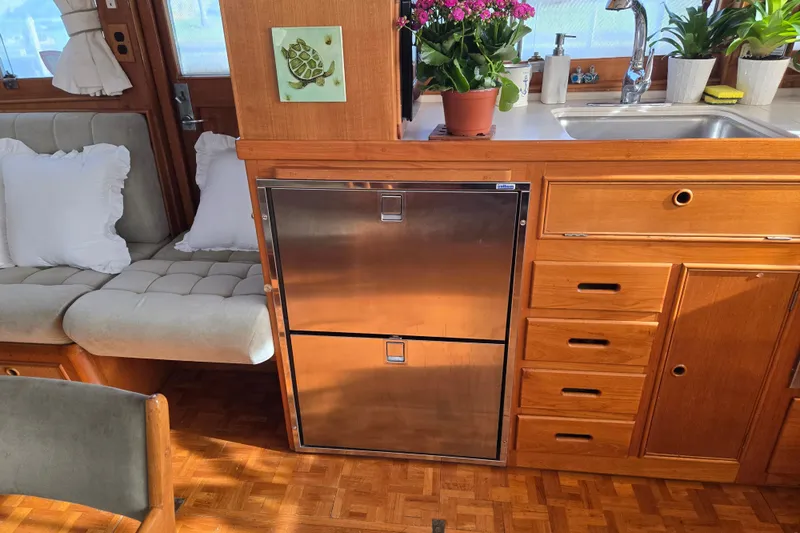 Slide: The Image of Interior of 1992 Grand Banks 46 Classic yacht with wooden cabinetry and stainless steel fridge. - 24