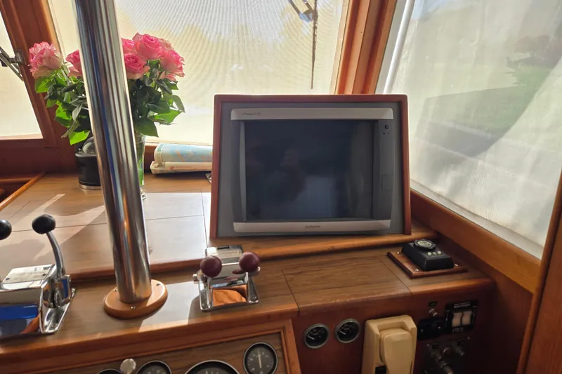 Slide: The Image of Interior helm of 1992 Grand Banks 46 Classic with navigation equipment and floral decor. - 34