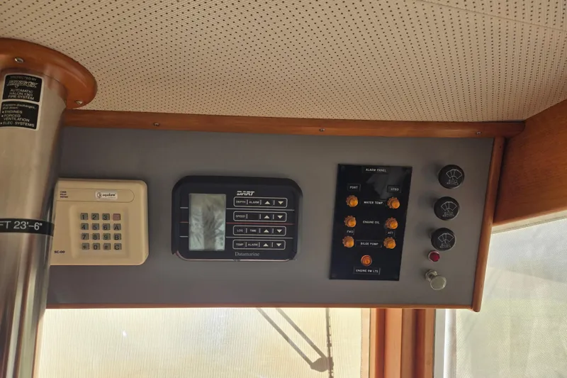 Slide: The Image of Control panel of a 1992 Grand Banks 46 Classic yacht, featuring navigation and alarm systems. - 38