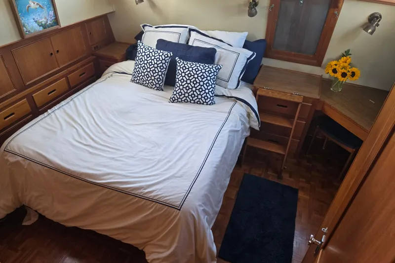 Slide: The Image of Cozy bedroom interior on a 1992 Grand Banks 46 Classic yacht with elegant bedding and sunflowers. - 41