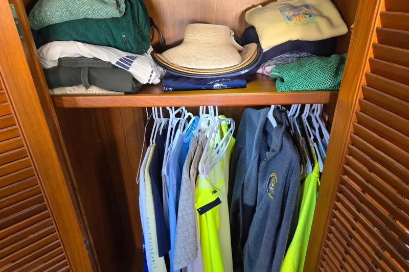 Slide: The Image of Closet on 1992 Grand Banks 46 Classic yacht with clothes and hats neatly organized. - 46