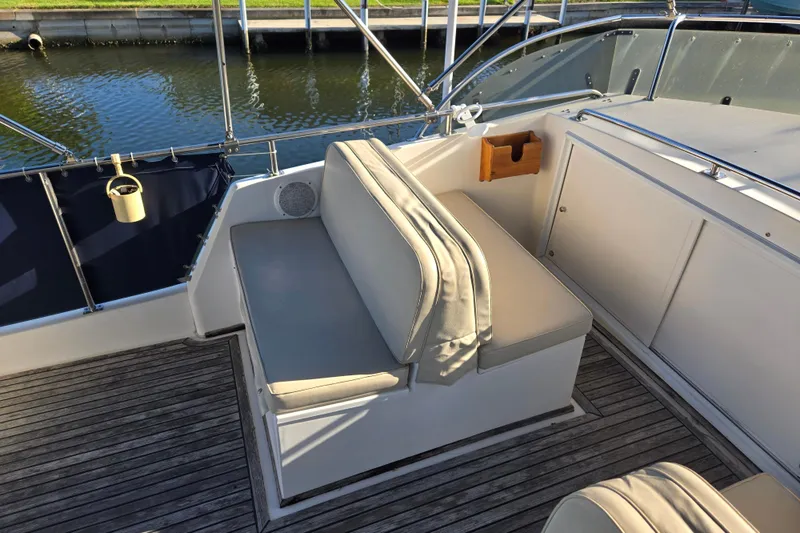 Slide: The Image of Grand Banks 46 Classic 1992 yacht seating area with cushioned bench and wooden deck. - 78