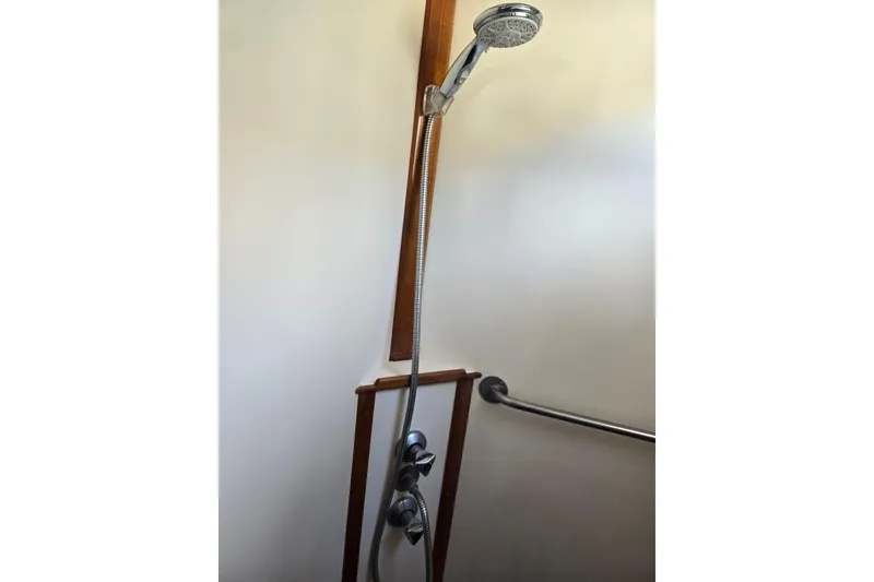 Slide: The Image of Shower area in 1992 Grand Banks 46 Classic yacht with chrome fixtures and wooden accents. - 8
