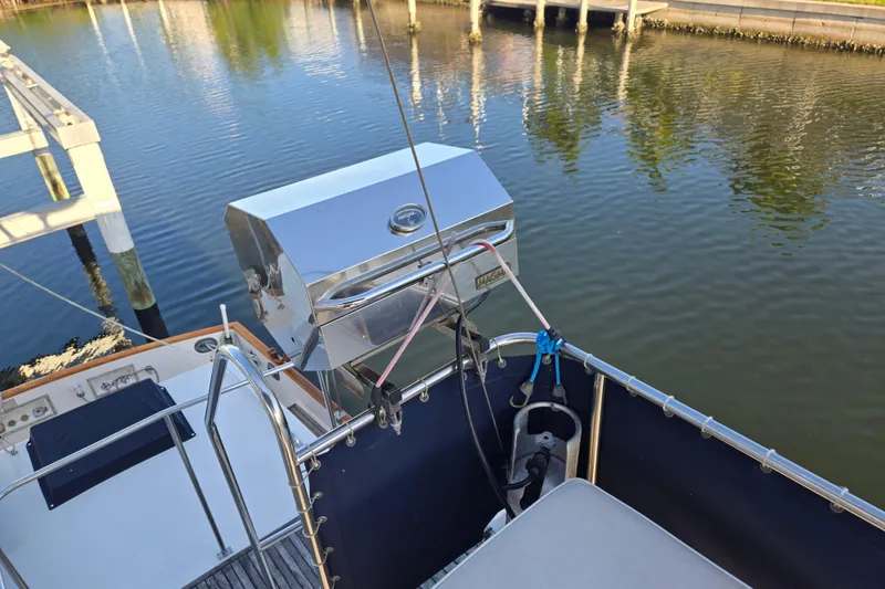 Slide: The Image of 1992 Grand Banks 46 Classic yacht with a stainless steel grill on deck by the water. - 87
