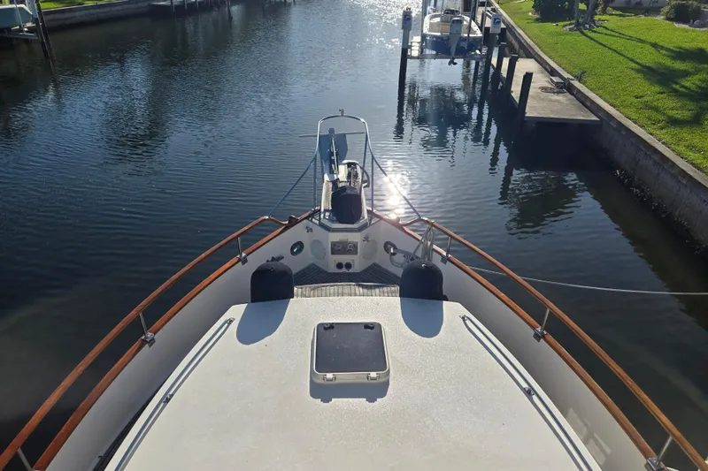 Slide: The Image of Bow view of 1992 Grand Banks 46 Classic yacht docked in a serene canal. - 89