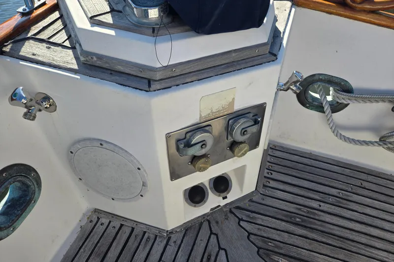 Slide: The Image of Deck controls on a 1992 Grand Banks 46 Classic yacht, featuring wooden flooring and nautical equipment. - 93