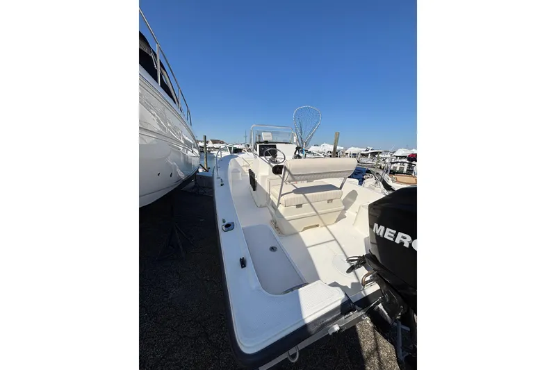 Slide: The Image of 2006 Mako 171 Center Console boat with Mercury engine, docked under clear blue sky. - 12
