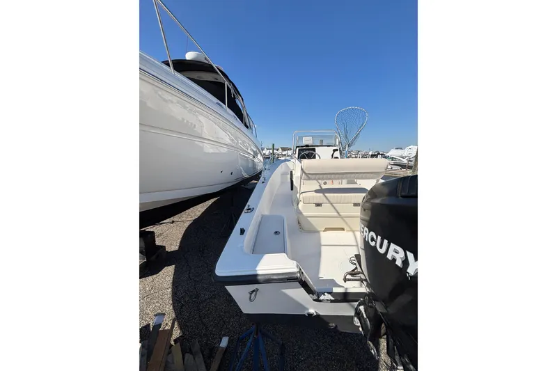 Slide: The Image of 2006 Mako 171 Center Console boat with Mercury engine, docked beside another vessel. - 13