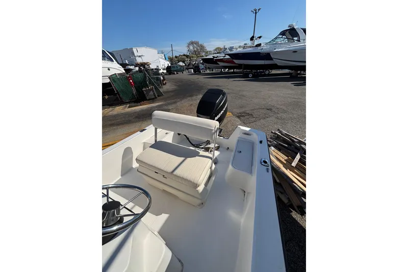 Slide: The Image of 2006 Mako 171 Center Console boat in a marina, featuring a steering wheel and seating. - 4