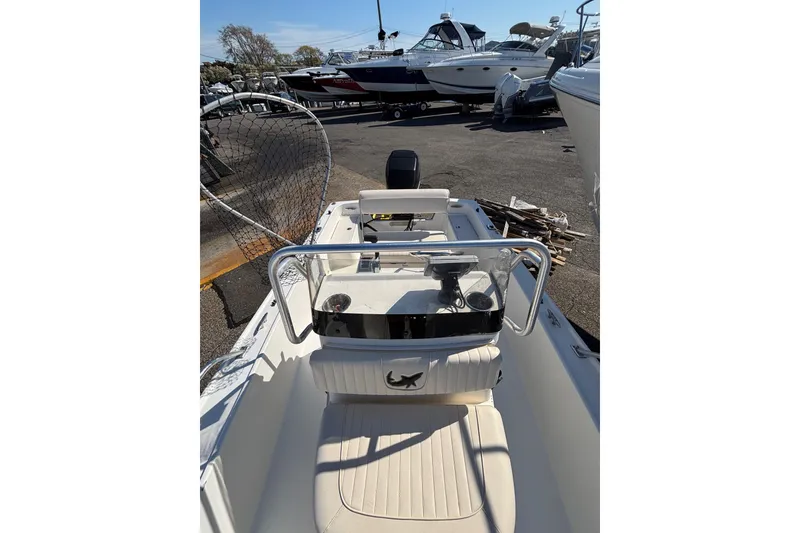 Slide: The Image of 2006 Mako 171 Center Console boat with fishing net, parked among other boats. - 6