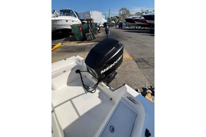 Slide: The Image of 2006 Mako 171 Center Console boat with Mercury outboard motor in a marina setting. - 8