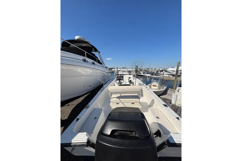 Slide: The Image of 2006 Mako 171 Center Console boat docked at marina under clear blue sky. - 9