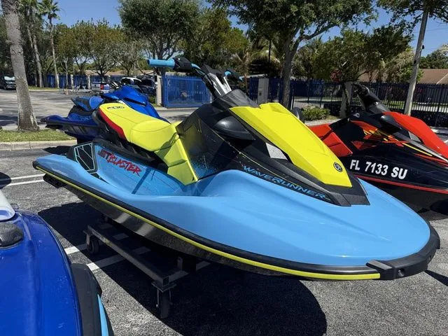 Slide: The Image of 2022 Yamaha WaveRunner JetBlaster in blue and yellow on a parking lot. - 5