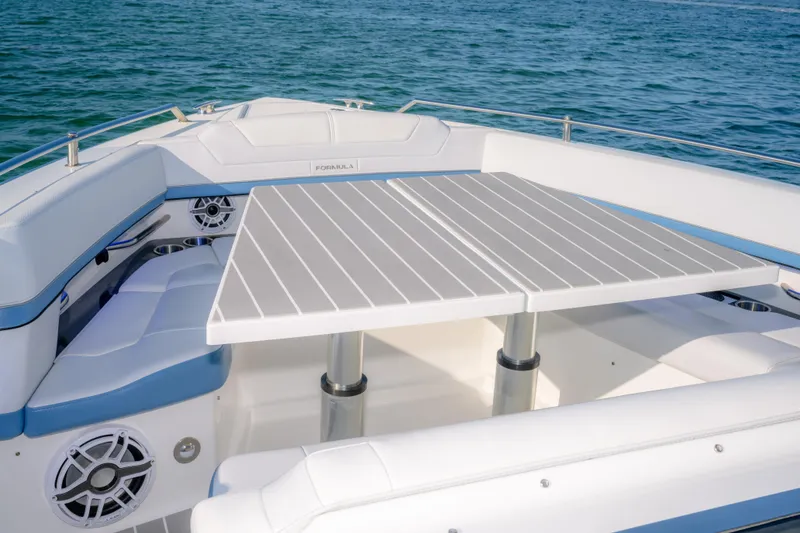 Slide: The Image of 2025 Formula 430 Super Sport Crossover boat interior with seating and table on open water. - 72