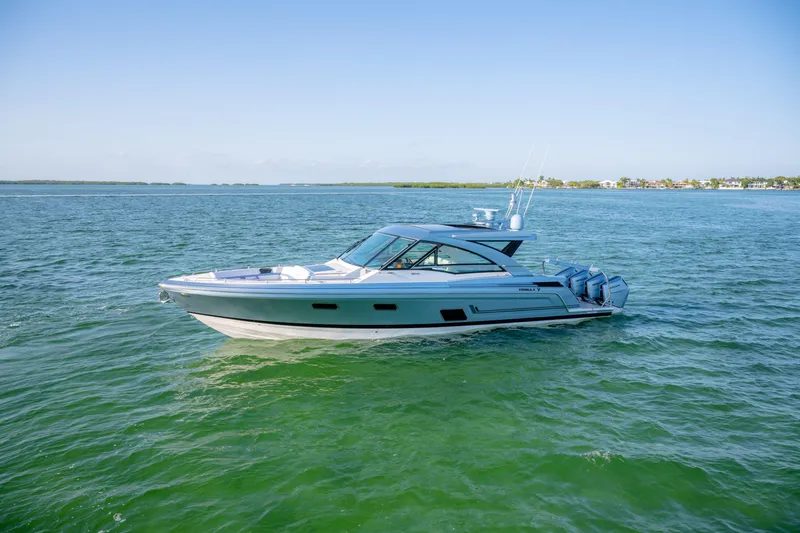 Slide: The Image of 2025 Formula 430 Super Sport Crossover boat cruising on open water under clear skies. - 95