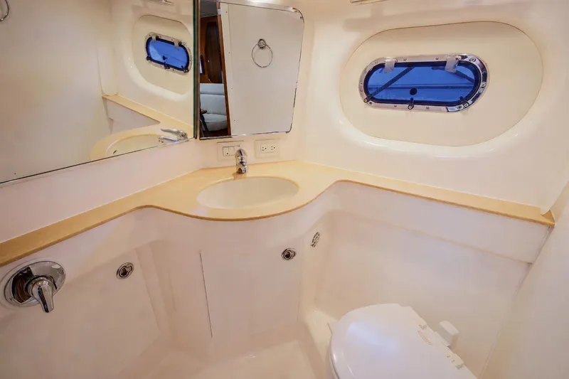 Slide: The Image of 2004 Tiara Yachts 3600 Sovran bathroom with sink, mirror, and porthole window. - 10