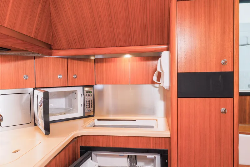 Slide: The Image of 2004 Tiara Yachts 3600 Sovran galley with wood cabinetry and modern appliances. - 5