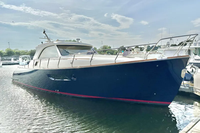 Slide: The Image of 2009 Mochi Craft 44 Dolphin yacht docked in a marina under a partly cloudy sky. - 1