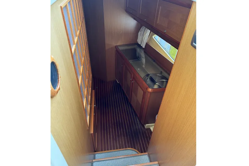 Slide: The Image of Interior of 2009 Mochi Craft 44 Dolphin yacht, featuring a compact wooden kitchenette. - 12