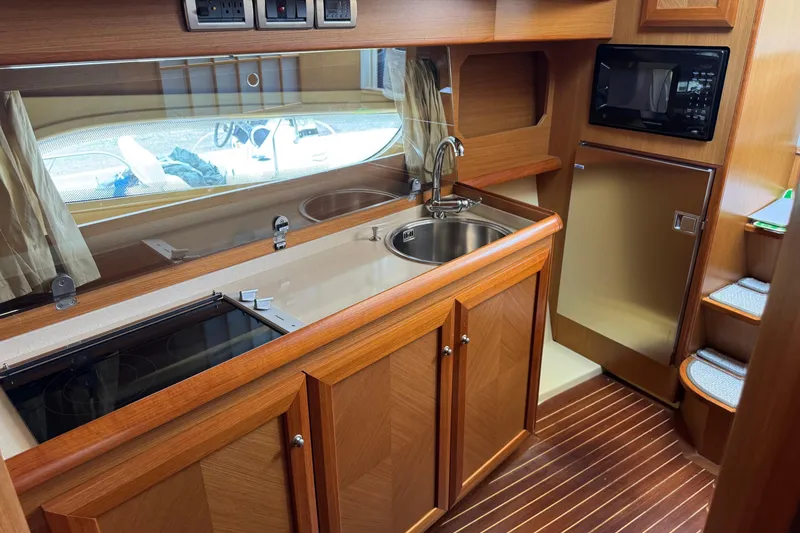 Slide: The Image of Luxurious 2009 Mochi Craft 44 Dolphin yacht kitchen with wood cabinetry and modern appliances. - 14