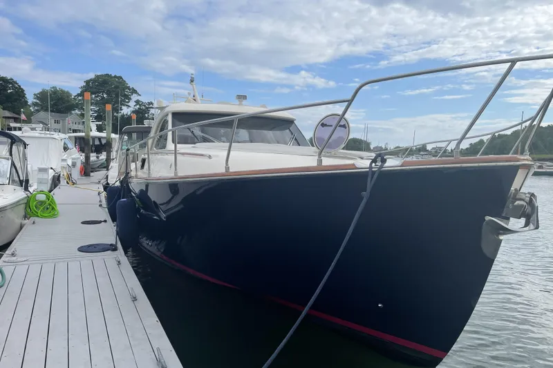 Slide: The Image of 2009 Mochi Craft 44 Dolphin yacht docked at marina under cloudy sky. - 2