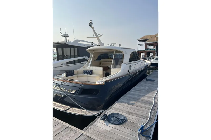 Slide: The Image of 2009 Mochi Craft 44 Dolphin yacht docked at marina, showcasing elegant design and spacious seating. - 3