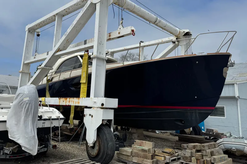 Slide: The Image of 2009 Mochi Craft 44 Dolphin yacht on a boat lift in a shipyard. - 5