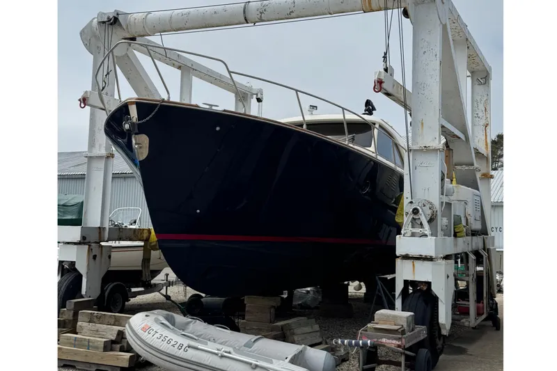 Slide: The Image of 2009 Mochi Craft 44 Dolphin yacht in dry dock, supported by a boat lift. - 6