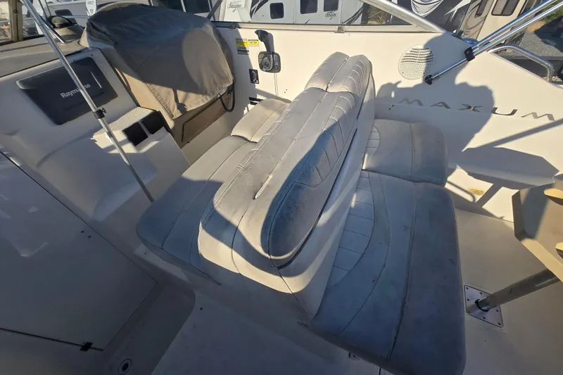 Slide: The Image of 2001 Maxum 2400 SCR boat interior with cushioned seating and control panel. - 15