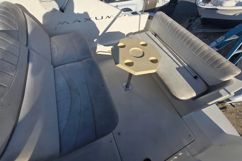 Slide: The Image of 2001 Maxum 2400 SCR boat interior with cushioned seating and a central table. - 17