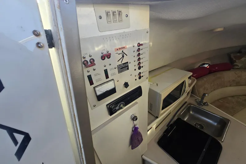Slide: The Image of Interior of 2001 Maxum 2400 SCR boat with control panel, microwave, and sink. - 18