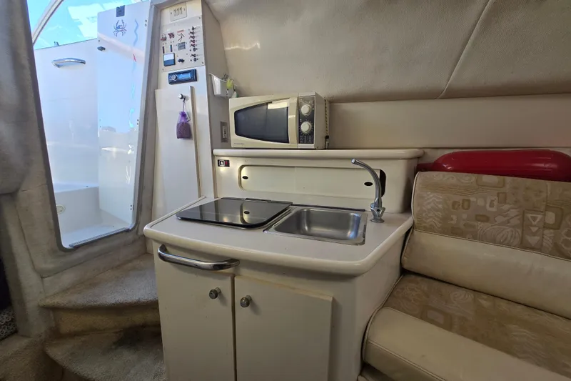 Slide: The Image of 2001 Maxum 2400 SCR boat interior with kitchenette, microwave, and seating area. - 21