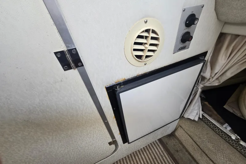 Slide: The Image of Interior of a 2001 Maxum 2400 SCR boat showing a vent, control panel, and cabinet. - 22