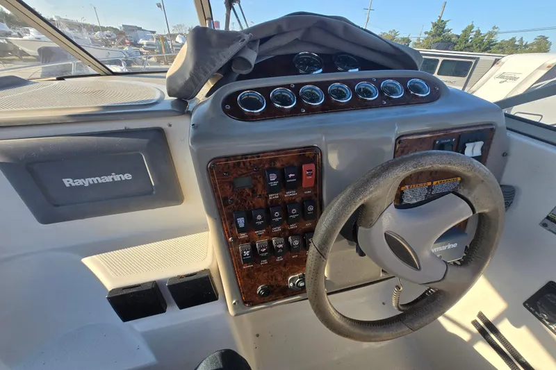 Slide: The Image of 2001 Maxum 2400 SCR boat dashboard with Raymarine equipment and steering wheel. - 25