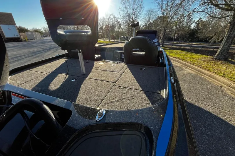 Slide: The Image of 2024 Nitro Z19 boat interior with seating and storage, parked outdoors in sunlight. - 4