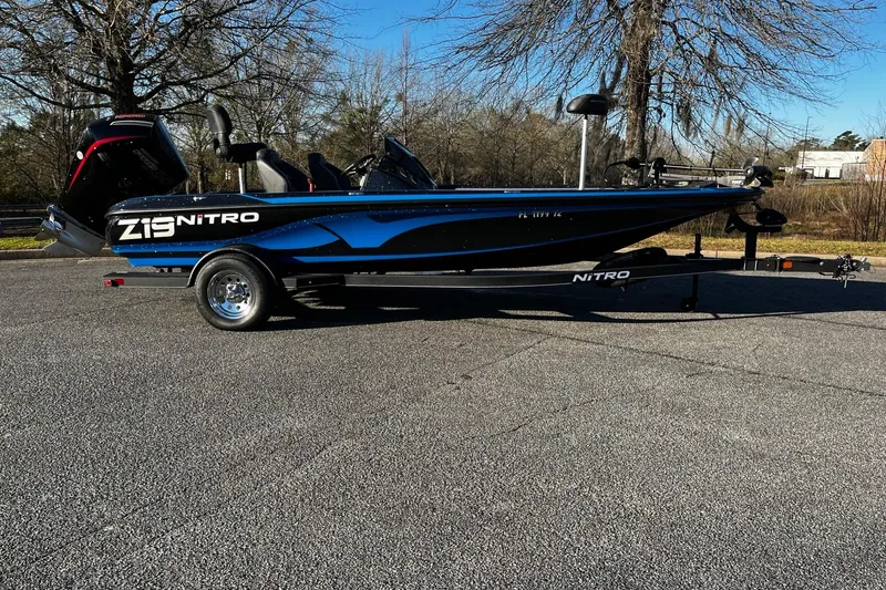 Slide: The Image of 2024 Nitro Z19 boat with trailer, parked outdoors on a sunny day. - 8