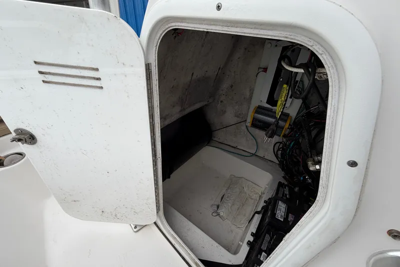 Slide: The Image of Open storage compartment on a 2017 Tidewater 198 CC Adventure boat, showing wiring and equipment. - 12