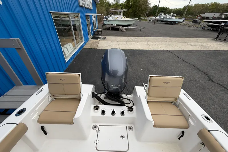 Slide: The Image of 2017 Tidewater 198 CC Adventure boat with dual seats and outboard motor at a marina. - 13