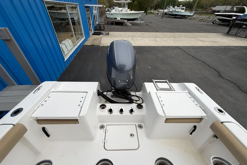 Slide: The Image of 2017 Tidewater 198 CC Adventure boat with outboard motor, docked near blue building. - 14