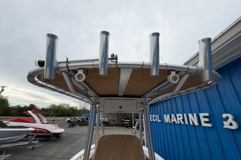 Slide: The Image of 2017 Tidewater 198 CC Adventure boat with T-top and rod holders at marine dealership. - 18