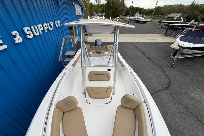 Slide: The Image of 2017 Tidewater 198 CC Adventure boat at a marine supply store, featuring beige seating. - 3