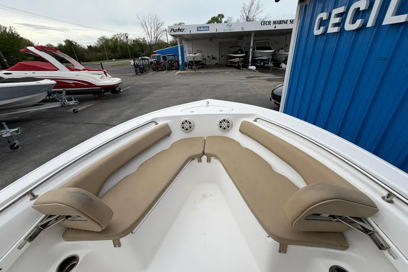 Slide: The Image of 2017 Tidewater 198 CC Adventure boat with beige seating at a marine dealership. - 4