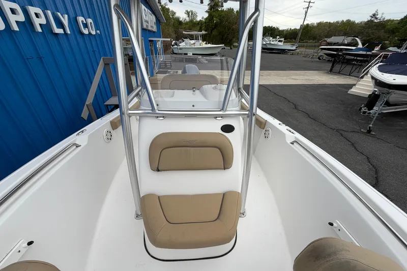 Slide: The Image of 2017 Tidewater 198 CC Adventure boat with beige seating, displayed outdoors near a blue building. - 5